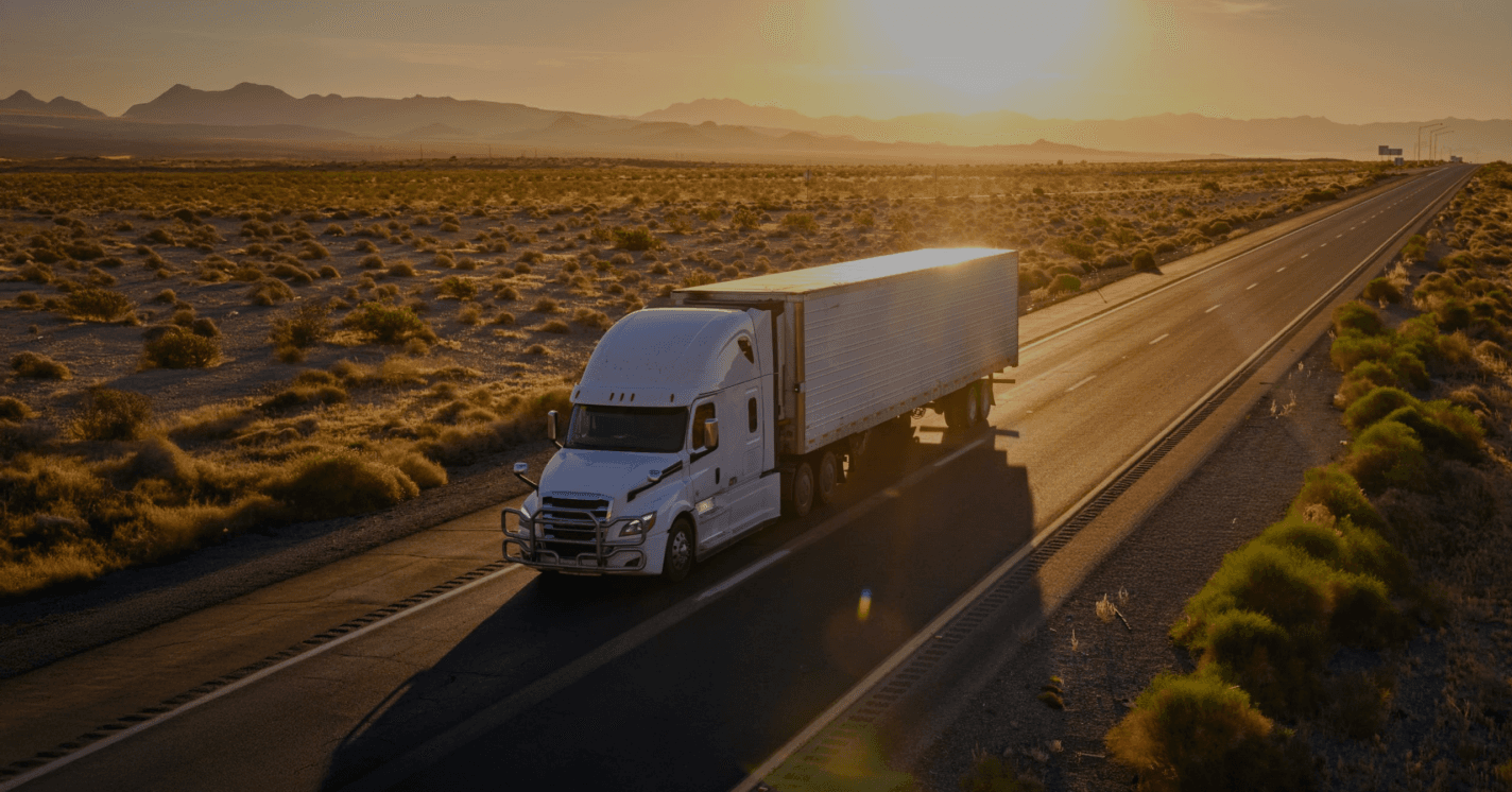 White USKO-branded Freightliner Cascadia tractor-trailer on an open highway for the USKO Premium Team Driver Program